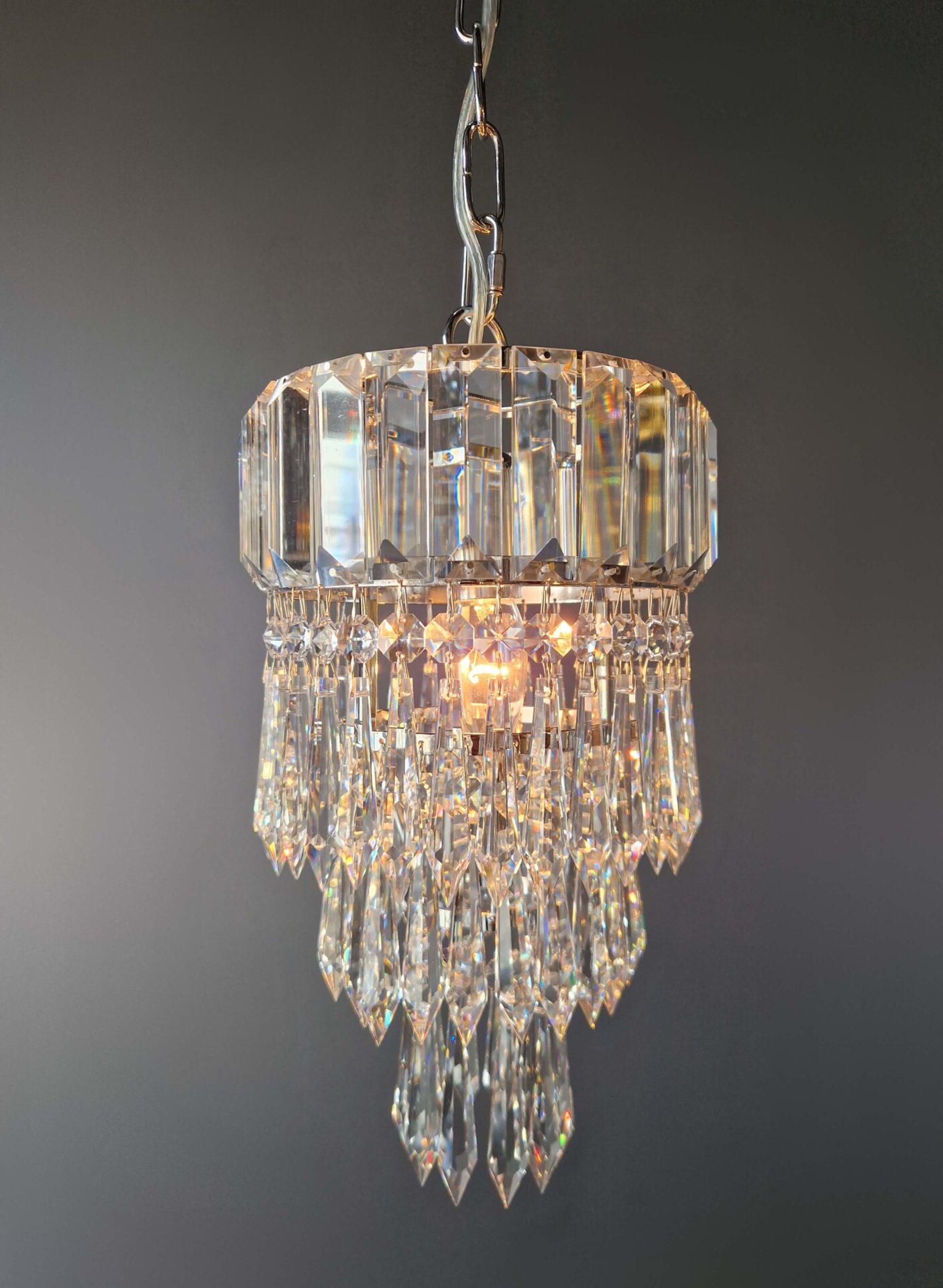 nahaufnahme glasdetail einer kleinen silbernen deckenleuchte Flur